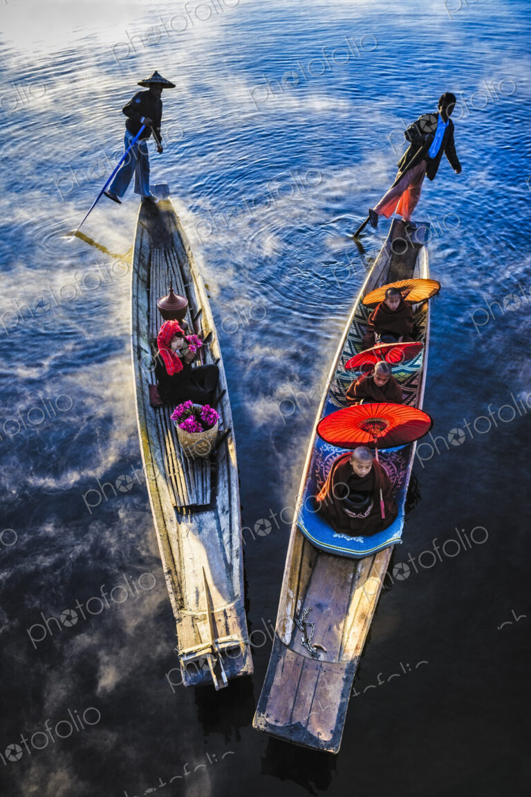Asian gondoliers rowing canoes on river
