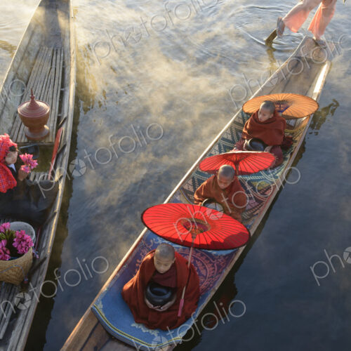 Asian gondoliers rowing canoes on river Asian gondoliers rowing canoes on river