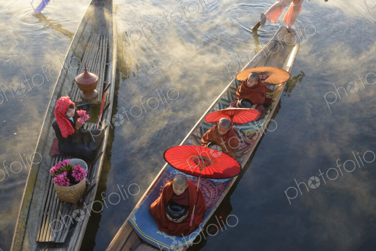 Asian gondoliers rowing canoes on river