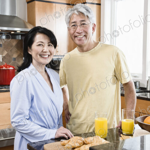 Asian man and woman in their new kitchen for breakfast. Asian man and woman in their new kitchen for breakfast.