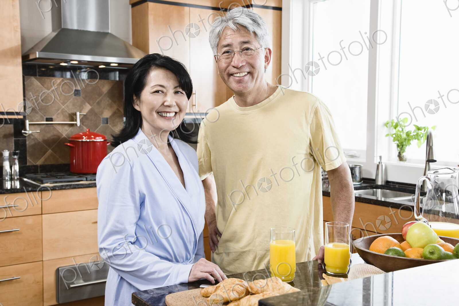 Asian man and woman in their new kitchen for breakfast.