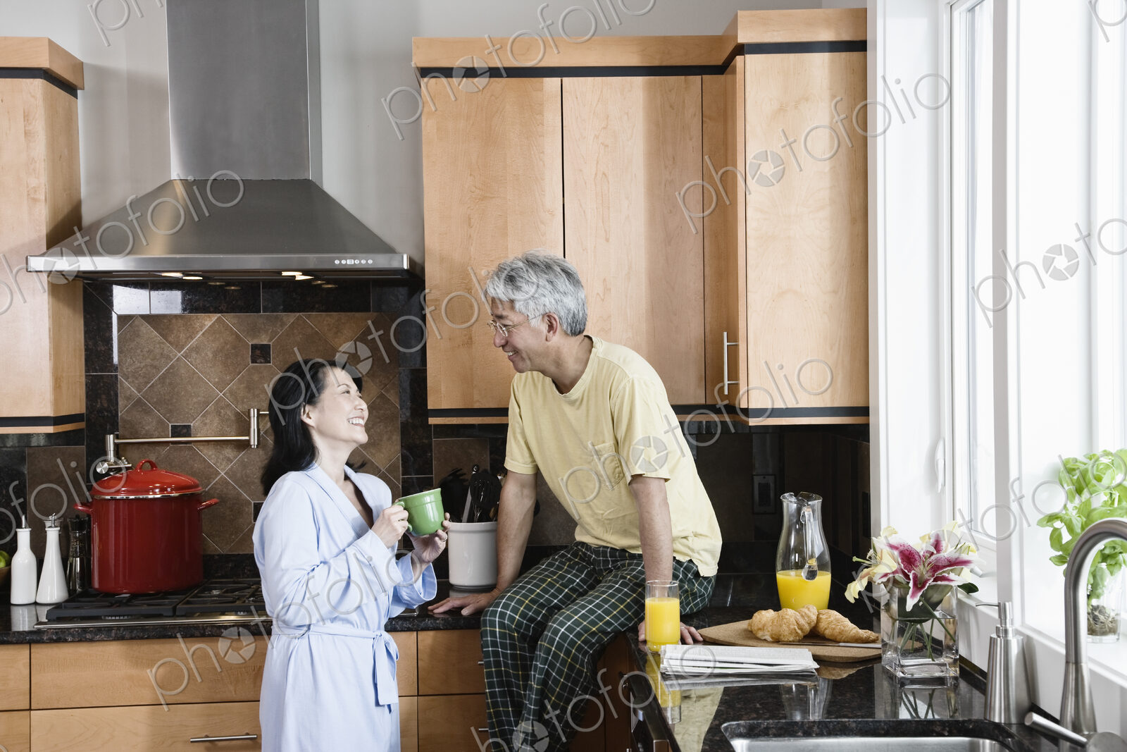 Asian man and woman in their new kitchen for breakfast.