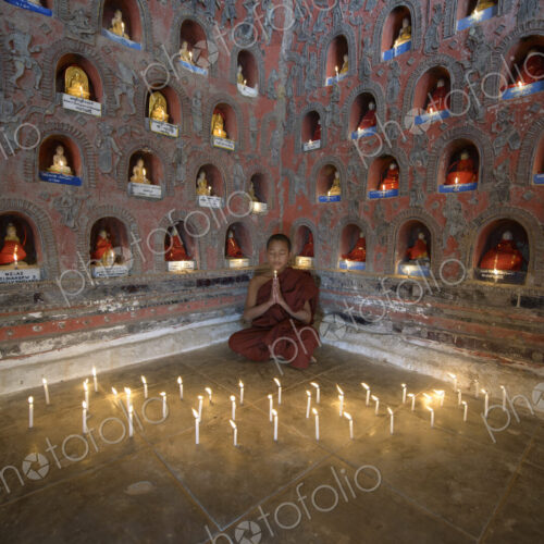 Asian monk-in-training praying in ancient temple Asian monk-in-training praying in ancient temple