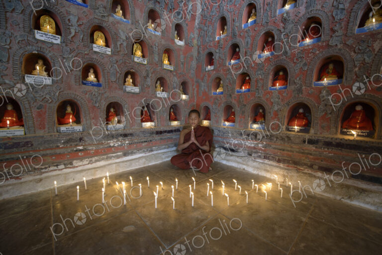 Asian monk-in-training praying in ancient temple