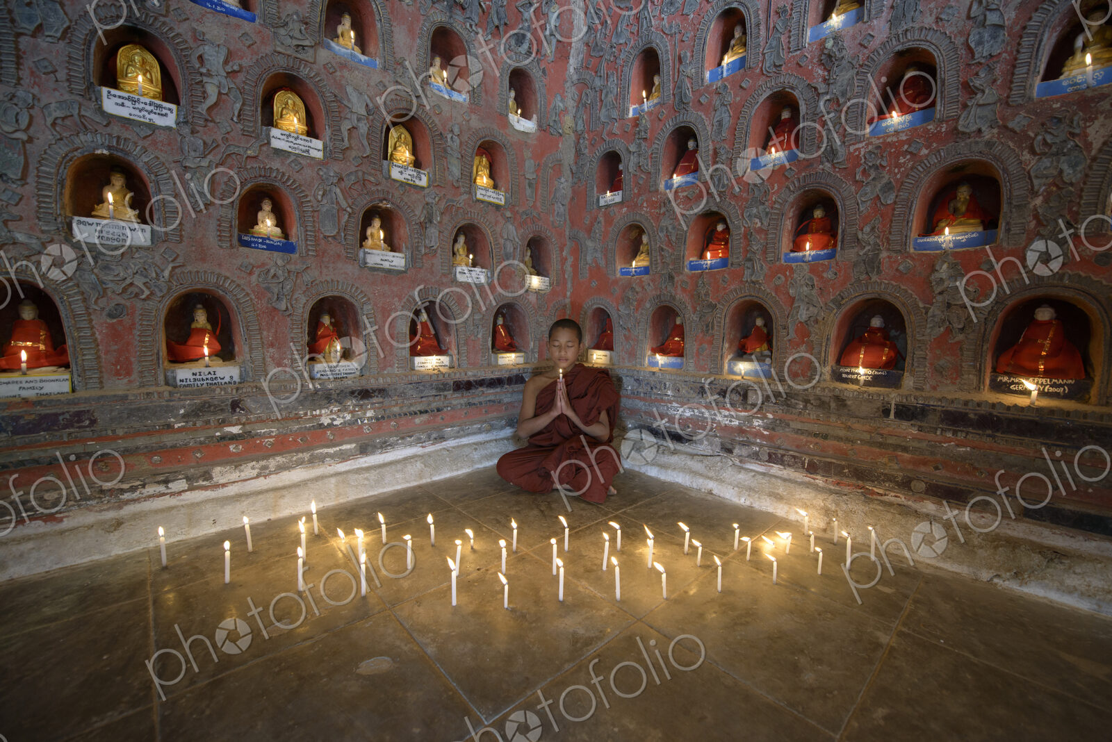 Asian monk-in-training praying in ancient temple