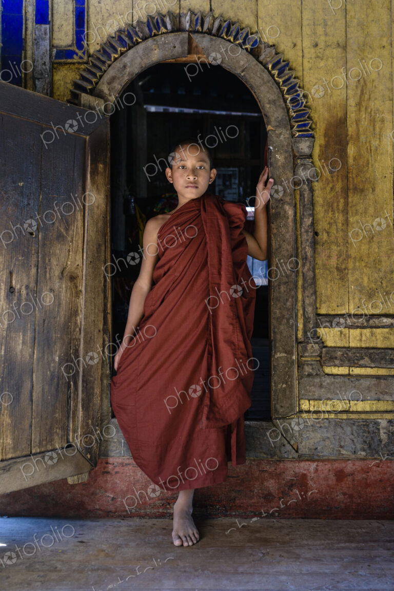 Asian monk-in-training walking out of temple archway