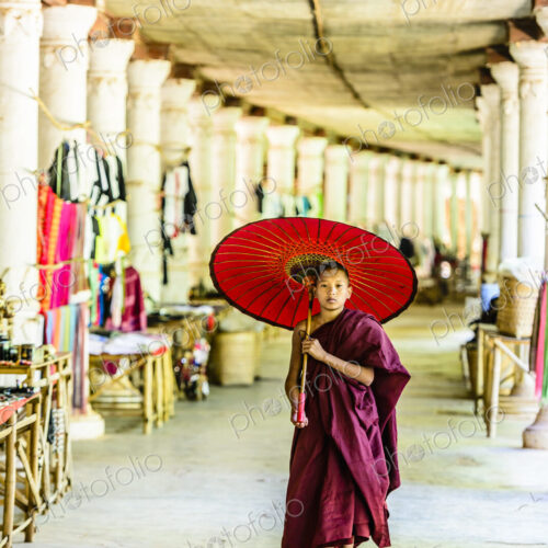 Asian monk-in-training with parasol walking in hallway Asian monk-in-training with parasol walking in hallway