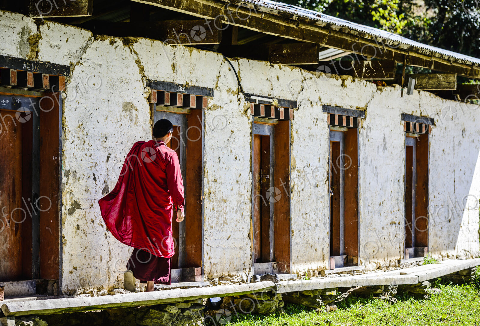 Asian monk walking by monastery doors