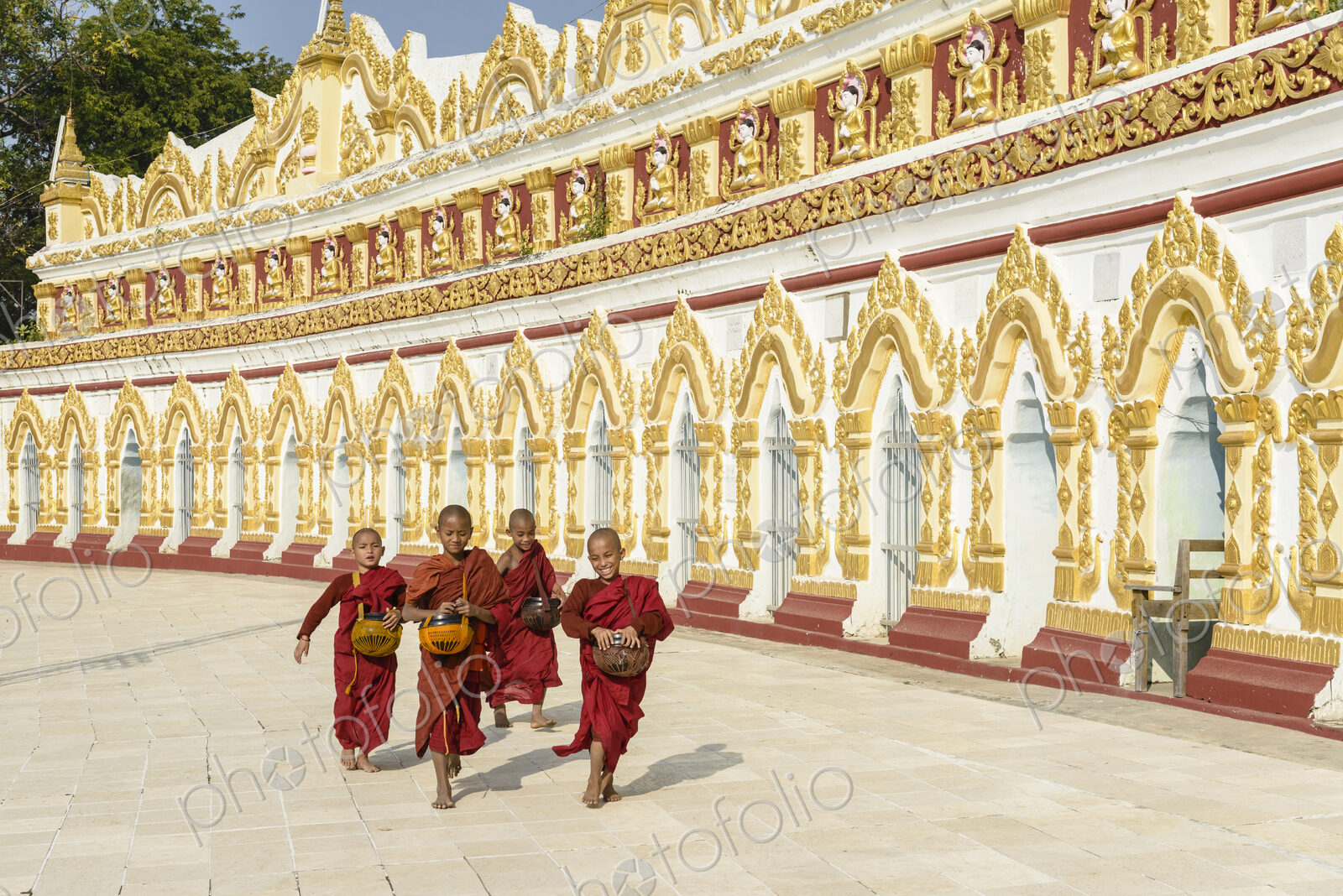 Asian monks-in-training running outside ornate temple