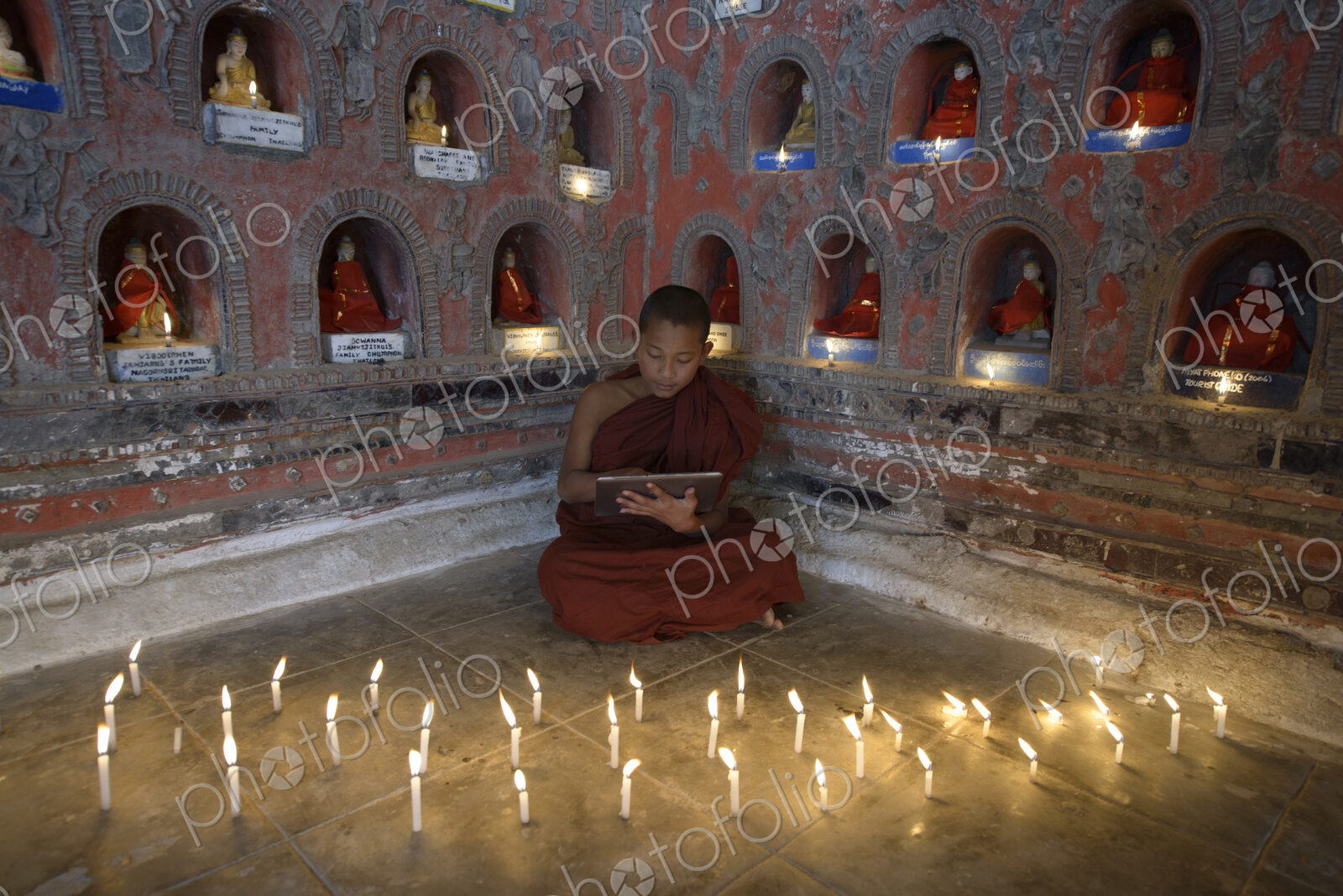 Asian monks-in-training using digital tablet in ancient temple