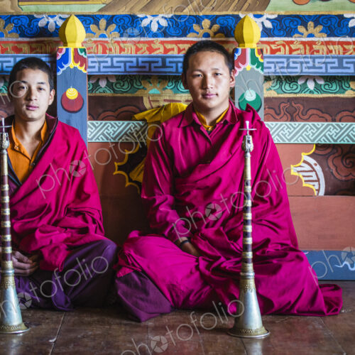 Asian monks sitting on temple floor