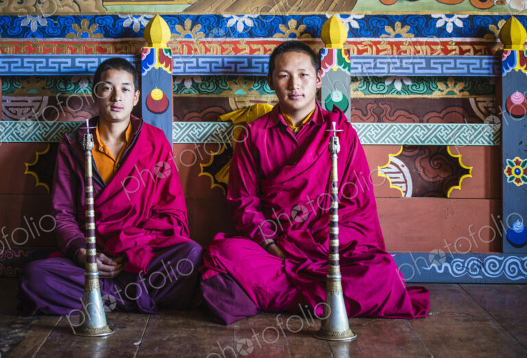 Asian monks sitting on temple floor