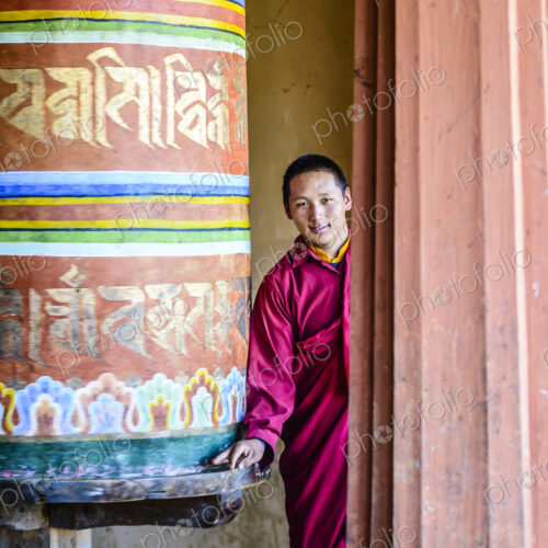 Asian monks standing by pillar in temple