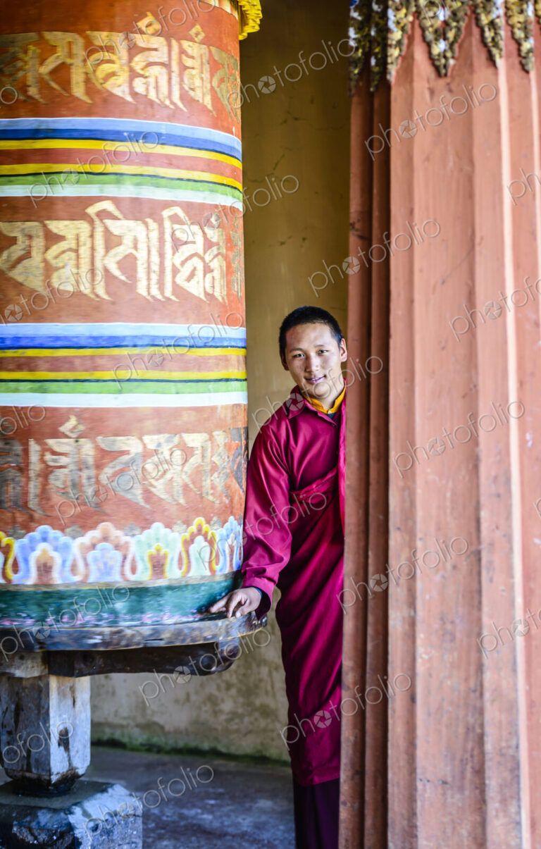 Asian monks standing by pillar in temple