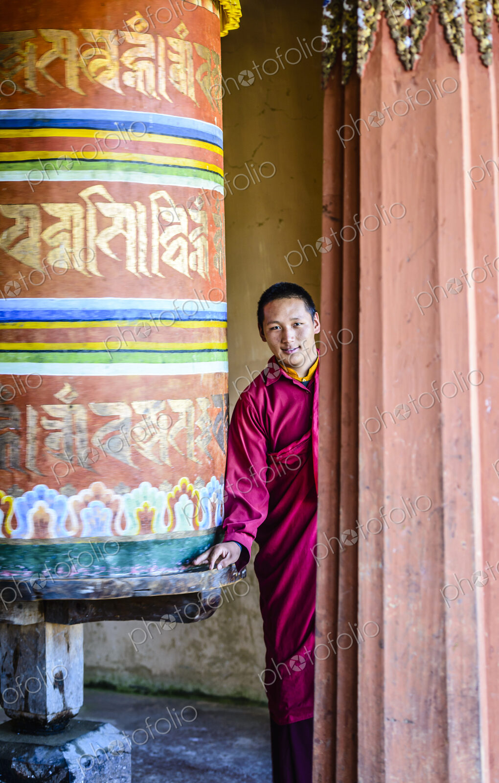 Asian monks standing by pillar in temple