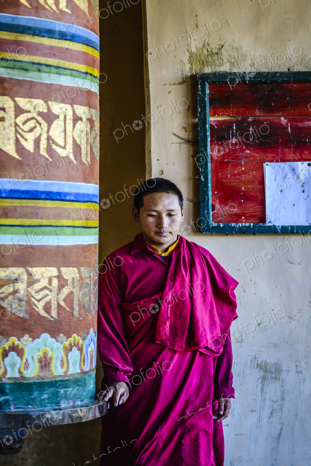 Asian monks standing by pillar in temple