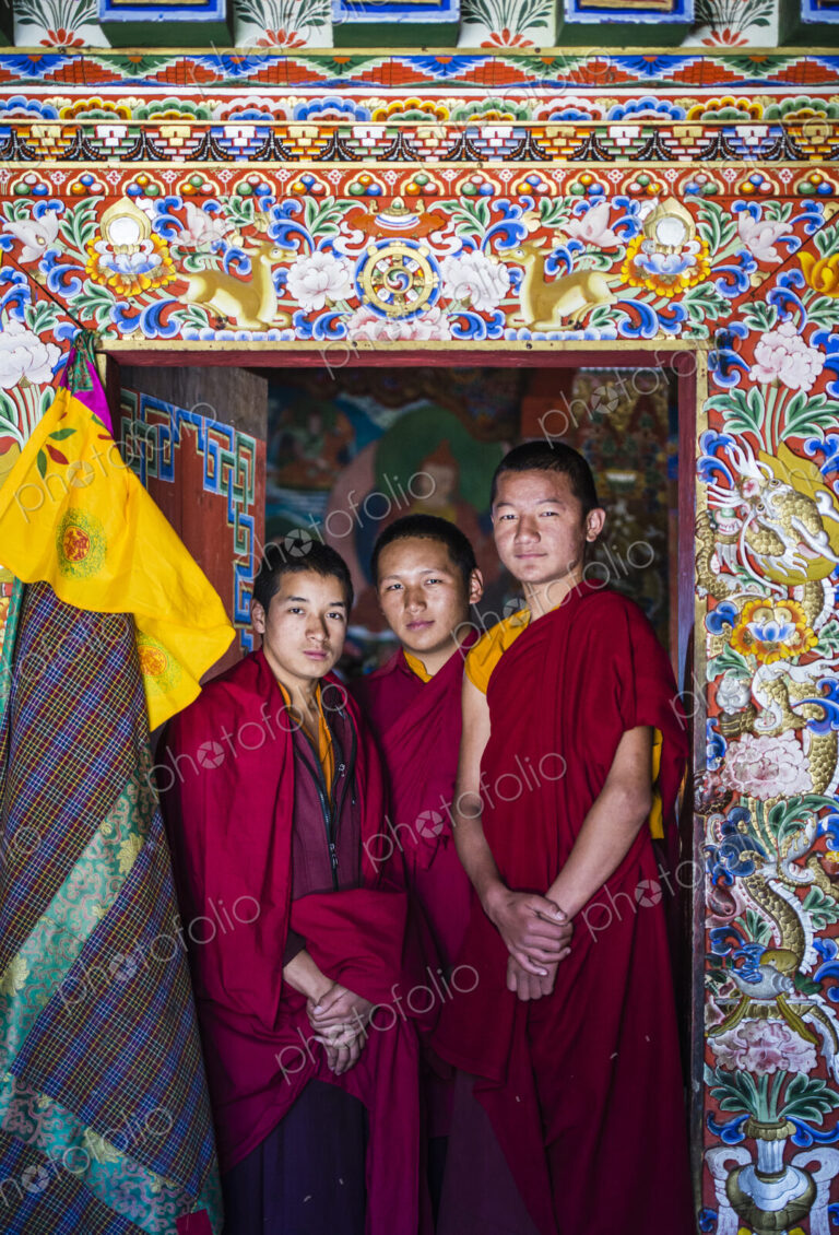 Asian monks standing in temple doorway