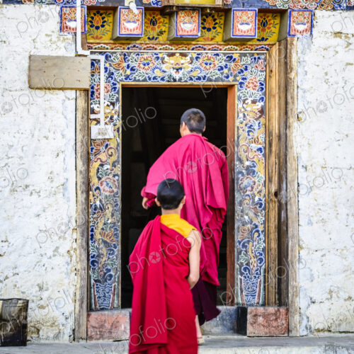 Asian monks walking in temple doorway