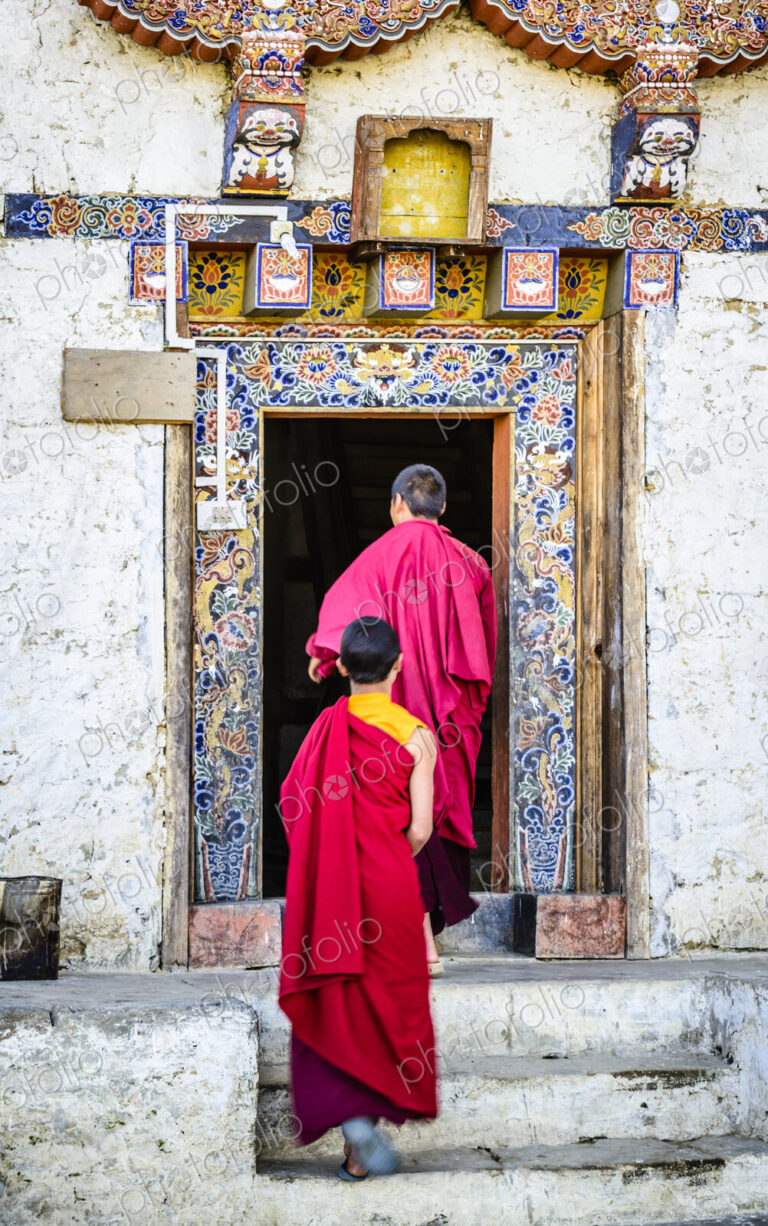 Asian monks walking in temple doorway
