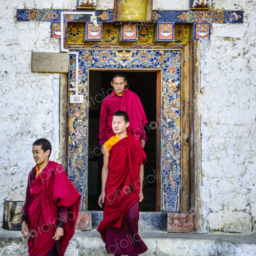Asian monks walking out temple doorway