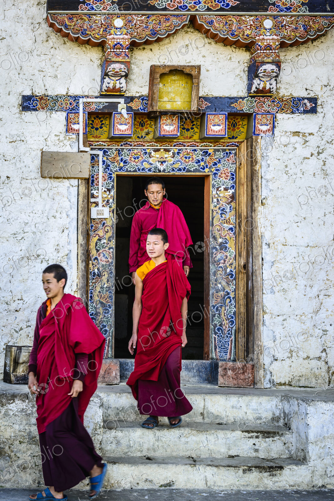 Asian monks walking out temple doorway