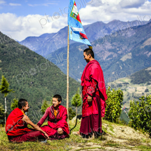 Asian monks with flag on remote hilltop Asian monks with flag on remote hilltop