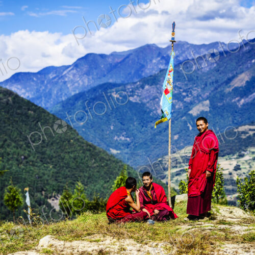Asian monks with flag on remote hilltop Asian monks with flag on remote hilltop