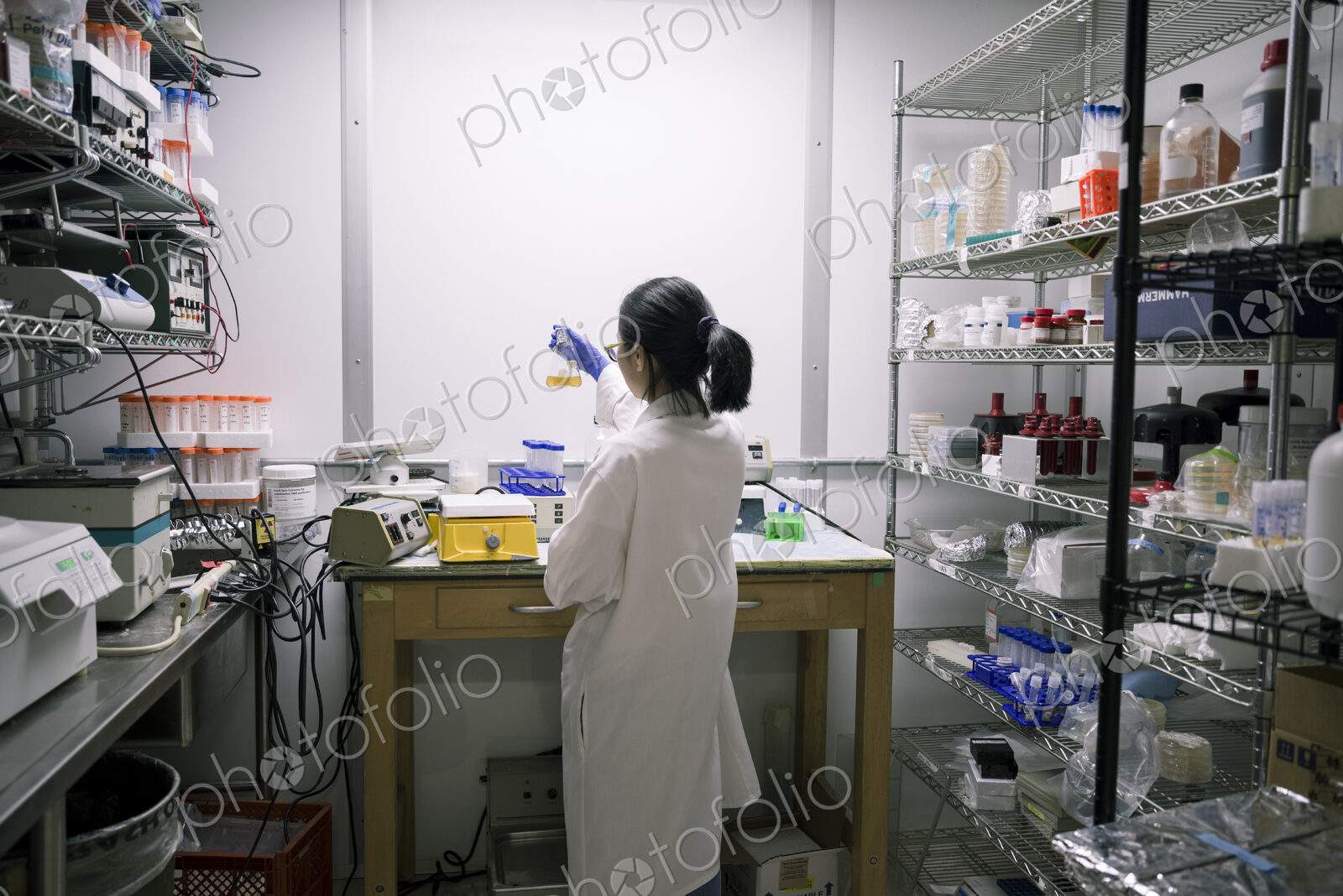 Asian scientist examining fluid in beaker