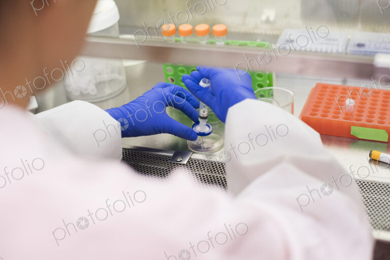 Asian scientist using syringe and petri dish
