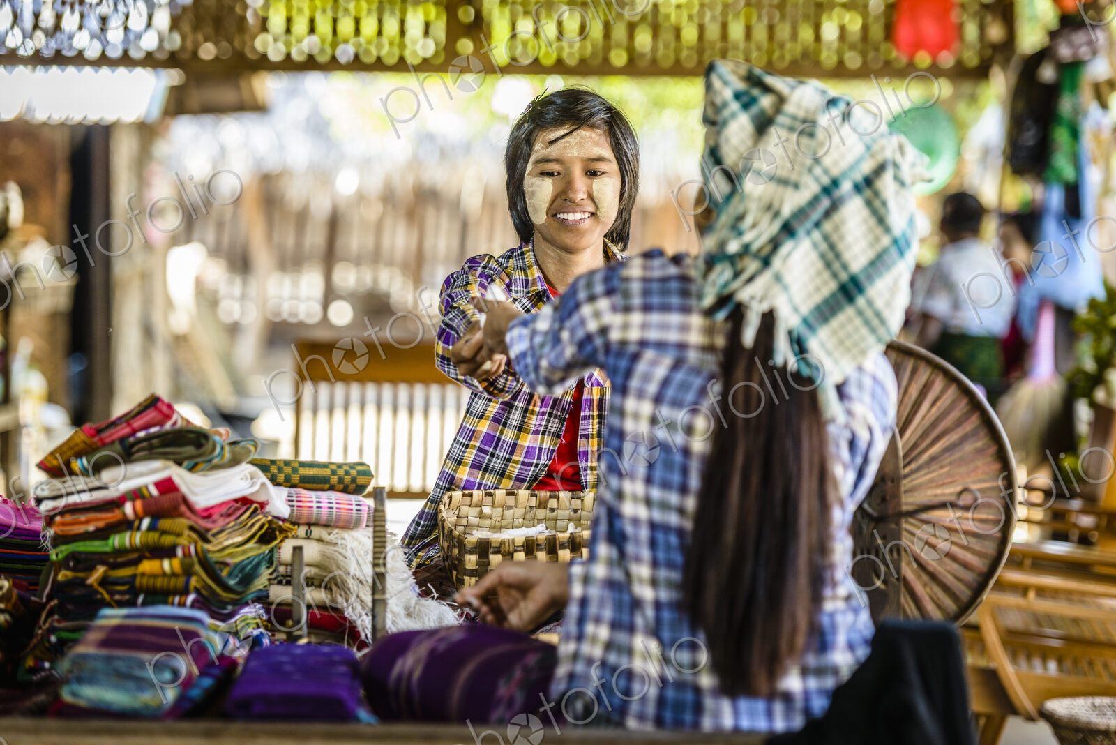 Asian teenage boy selling fabric at market