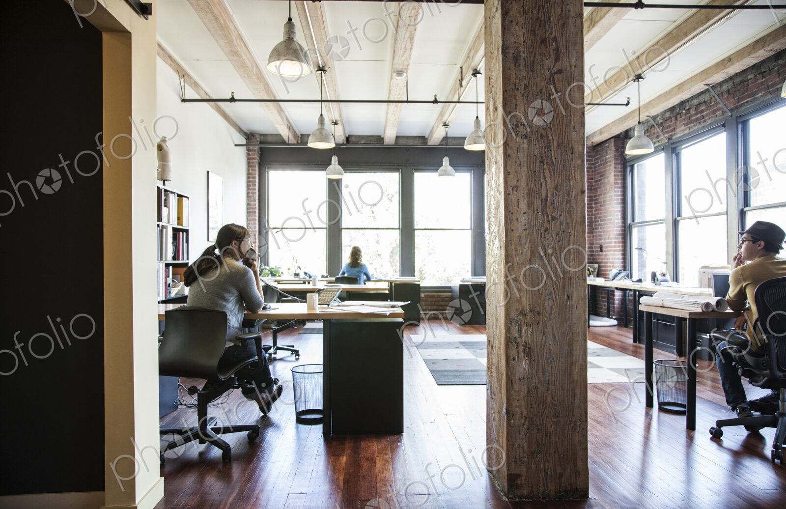 Asian woman and HIspanic man working at their desks in a creative office.
