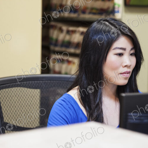 Asian woman and east indian woman working on a computer in a medical office. Asian woman and east indian woman working on a computer in a medical office.