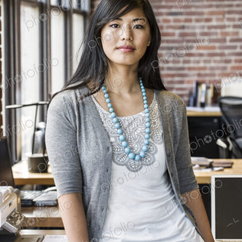 Asian woman at her creative office work station. Asian woman at her creative office work station.