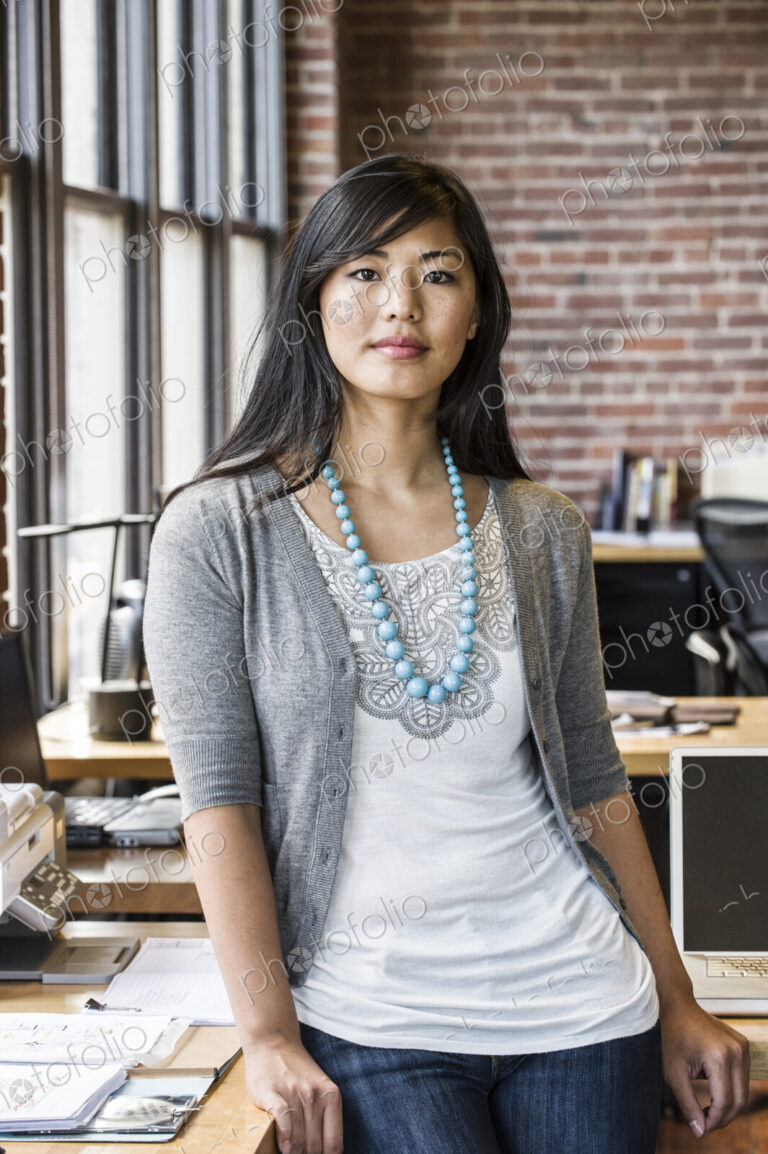 Asian woman at her creative office work station.