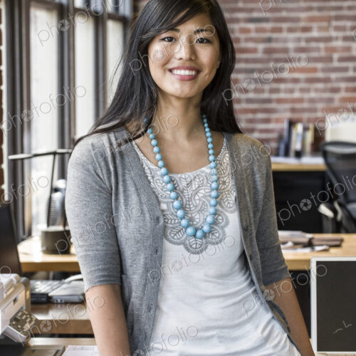 Asian woman at her creative office work station. Asian woman at her creative office work station.