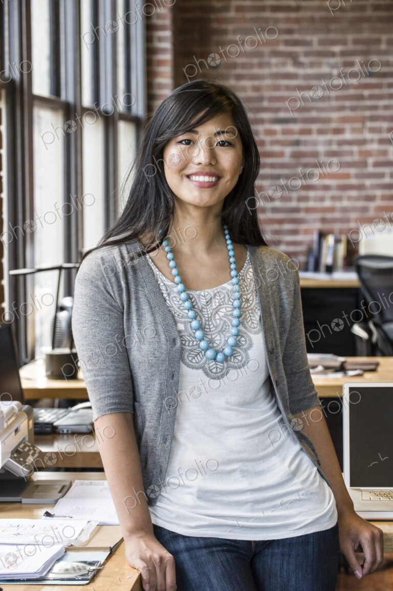 Asian woman at her creative office work station.