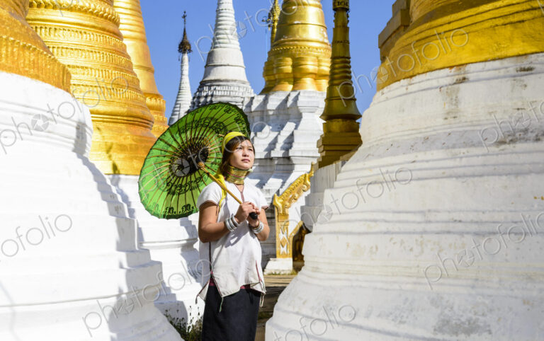 Asian woman carrying parasol at temple