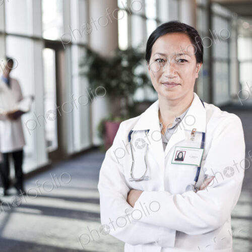 Asian woman doctor in lab coat with stethescope. Asian woman doctor in lab coat with stethescope.