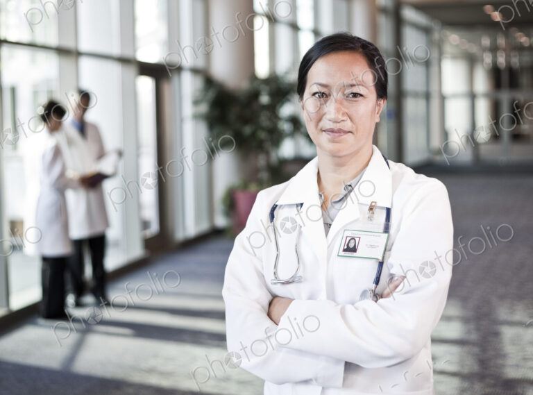 Asian woman doctor in lab coat with stethescope.