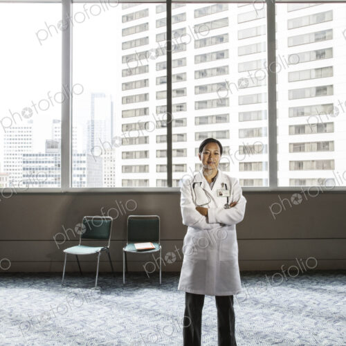 Asian woman doctor in lab coat with stethescope.