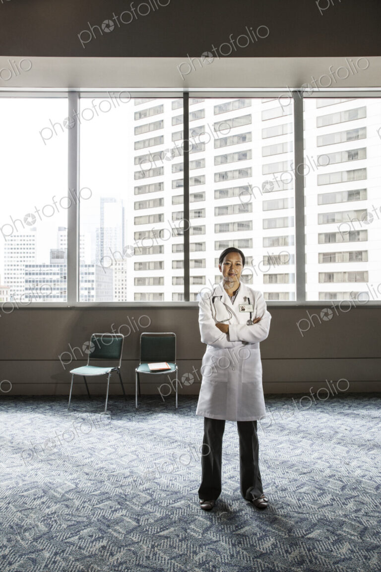 Asian woman doctor in lab coat with stethescope.