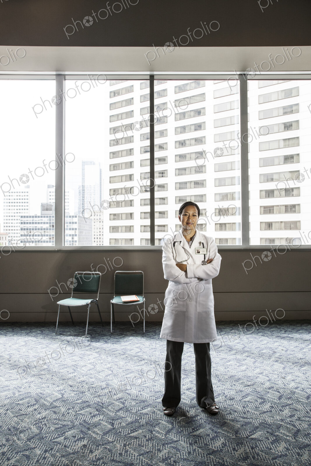 Asian woman doctor in lab coat with stethescope.