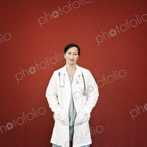 Asian woman doctor in lab coat with stethescope.