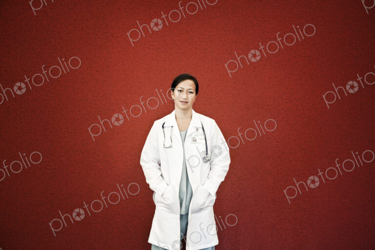 Asian woman doctor in lab coat with stethescope.