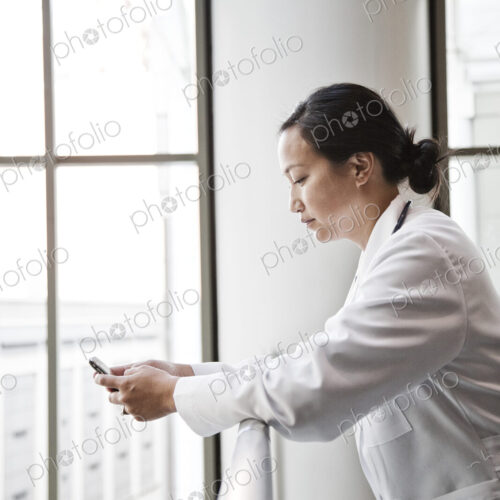 Asian woman doctor texting.