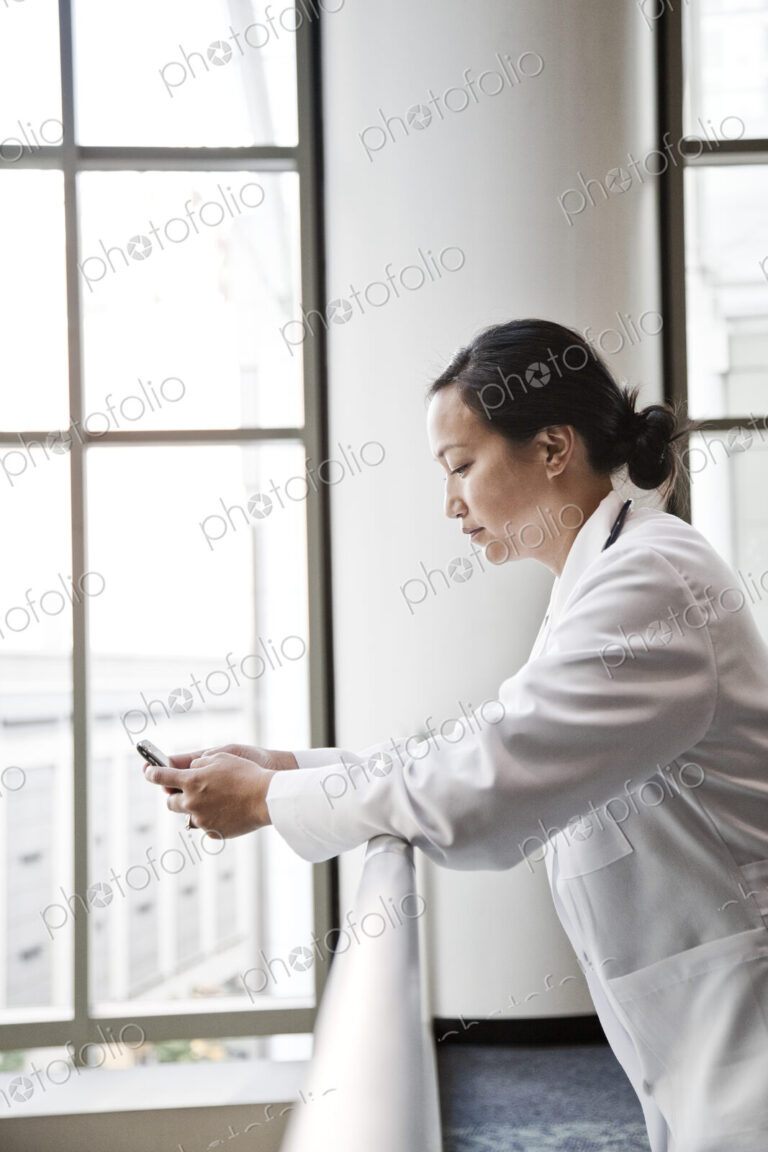 Asian woman doctor texting.