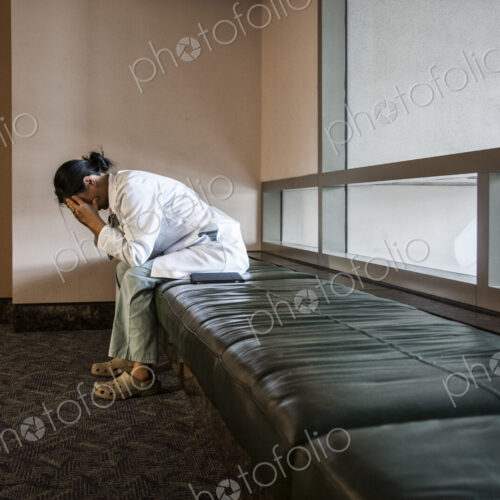 Asian woman doctor under stress sitting on a bench in a hospital. Asian woman doctor under stress sitting on a bench in a hospital.