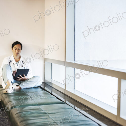 Asian woman doctor using a notebook computer and wearing a lab coat and stethescope. Asian woman doctor using a notebook computer and wearing a lab coat and stethescope.