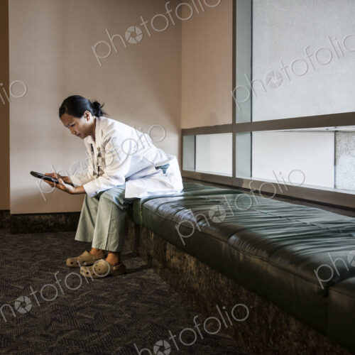Asian woman doctor using a notebook computer and wearing a lab coat and stethescope. Asian woman doctor using a notebook computer and wearing a lab coat and stethescope.