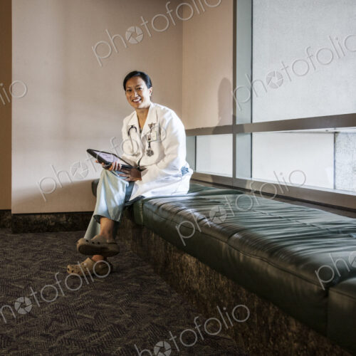 Asian woman doctor using a notebook computer and wearing a lab coat and stethescope. Asian woman doctor using a notebook computer and wearing a lab coat and stethescope.